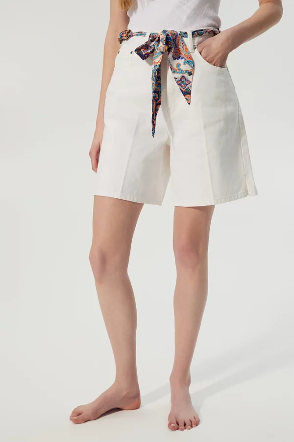 Un bermuda denim blanc avec un foulard à nouer à la taille.